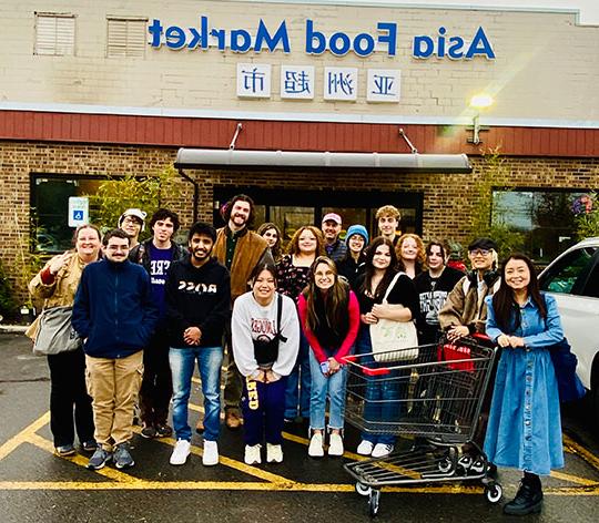 group of people standing in front of an Asian supermarket